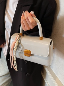 Creamy white small crossbody handbag with gold hardware and a cute tennis racket charm