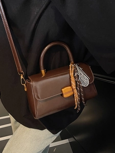 Vintage dark brown faux leather shoulder bag with gold buckle and tennis racket charm