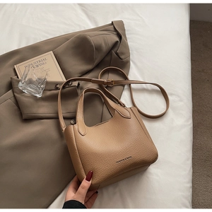 Detail of camel bucket bag featuring lychee grain leather texture and metallic hardware
