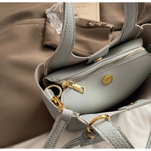 Detail view of light blue lychee pattern leather handbag showing golden hardware and interior