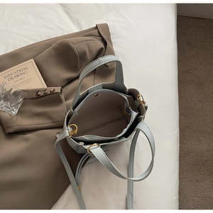 Detail view of light blue pebbled leather bucket bag showing inner zipper compartment