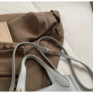Close-up of light blue lychee pattern leather handbag with premium gold hardware buckles