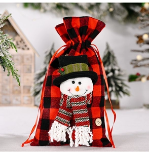 Detail of red and black buffalo plaid Christmas gift bag with a 3D snowman character