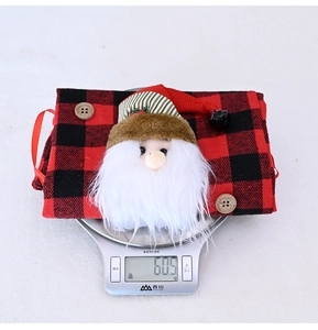 Detailed view of red and black buffalo plaid Christmas gift bag weighing 60.5g on scale