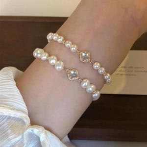 Baroque pearl clover bracelet with gold metal beads and iridescent floral charms