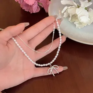 Französische Perlenhalskette mit silbernem Schleifenanhänger für einen eleganten Look