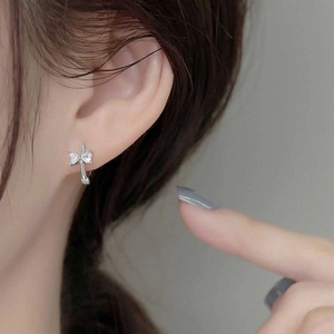 Elegant silver bow earrings with marquise-cut zircon stones on a female model