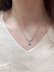 Gros plan d'un collier pendentif en zircon élégant avec détail en épi porté sur le décolleté