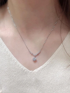 Gros plan d'un collier avec pendentif en zircon étincelant en forme de V sur chaîne argentée