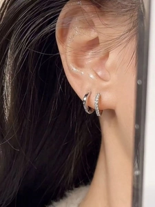 Close-up of a silver geometric hoop earring set with polished finish and pavé cubic zirconia