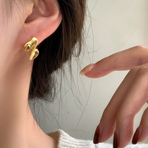 Eleganti orecchini in metallo liquido attorcigliato dorato con design fluido irregolare