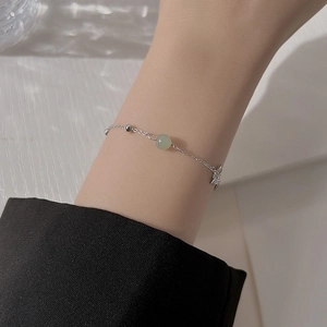 Elegant silver butterfly bracelet with Hetian jade bead worn by model on wrist