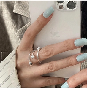 Close-up of triple-layer silver spiral bead ring worn on finger for a modern style