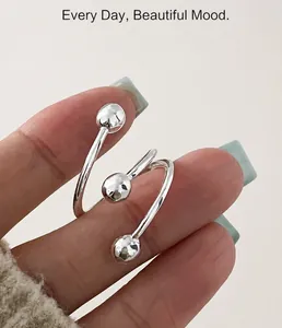 Macro shot of silver triple spiral ring with hammered metal beads on model hand