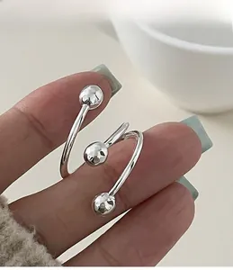 Macro shot of silver triple spiral ring with hammered metal beads on model hand
