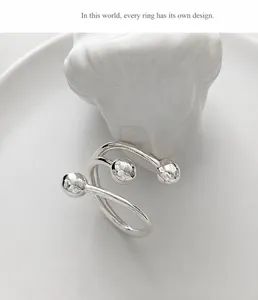 Artistic silver multi-layer open ring with hammered beads on a ceramic tray