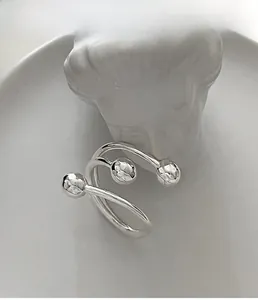 Artistic silver multi-layer open ring with hammered beads on a ceramic tray