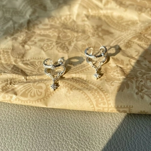 Detail of silver double-layer ear cuff with star pendant and sparkling zircon