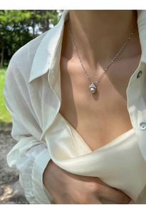 Détail d'une perle grise élégante avec capuchon en diamant sur une robe en soie