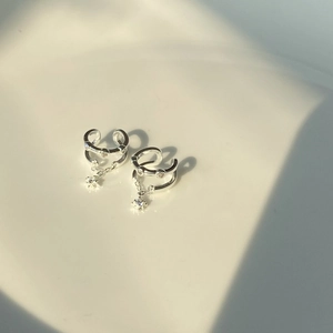 Minimalist silver double-layered ear cuff with star zircon tassels on a white background