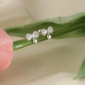 Silver bow heart drop earrings on a tulip flower stem showing elegant sweet design
