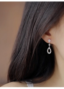 Close-up of elegant silver teardrop earrings with sparkling cubic zirconia on a model