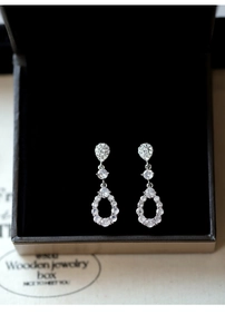 Detail of silver drop earrings with clear cubic zirconia on black velvet background