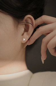 Vue détaillée du clou d'oreille feuille argentée avec design à trois feuilles et métal brossé