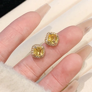 Sparkling square yellow zircon stud earrings with crystal halo shown on model ear