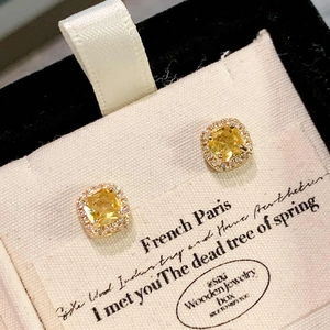 Macro detail of square yellow zircon earrings with micro-pave setting on gold studs