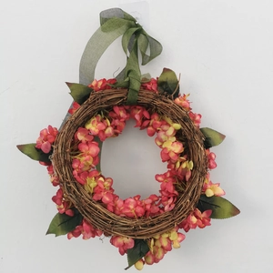 Fall hydrangea wreath with pink flowers and green ribbon on a rustic vine base