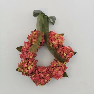 Detail of fall hydrangea wreath with gradient red flowers and olive green ribbon bow
