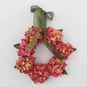 Close-up of pink and yellow artificial hydrangea wreath with a green ribbon