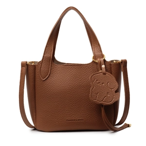 Vintage dark brown leather bucket bag with top handles and a dog charm in a front view