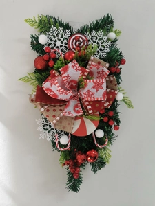 Detail eines Weihnachts-Tränengestecks mit Zuckerstangen, Tannenzweigen und Schleife