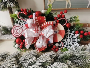 Nahaufnahme der Weihnachtsdeko mit roter Schleife, Zuckerstangen und grünen Tannenzweigen