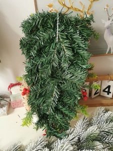 Detailansicht eines künstlichen Tannenbaum-Hängers mit roten Beeren als Weihnachtsdeko