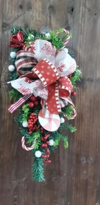 Detail der Weihnachts-Türdekoration mit Zuckerstangen Beeren und Dekoschleifen