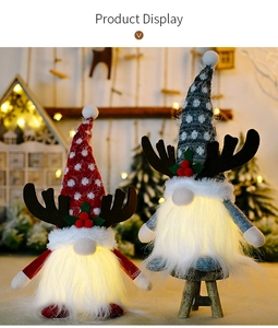 Close-up of glowing Christmas gnomes with reindeer antlers and festive LED warm lights