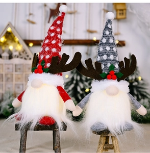 Close-up of lighted Christmas gnomes with antlers sitting on a mini wooden bench