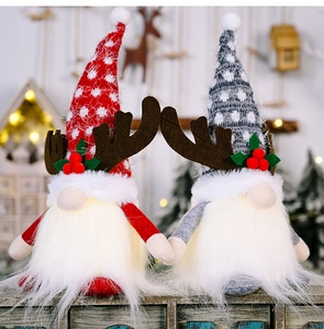 Close-up of glowing Christmas gnomes with reindeer antlers and warm LED lighting effect