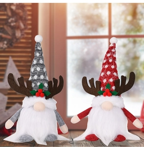 Close-up of two Christmas gnomes with reindeer antlers and festive knitted hats