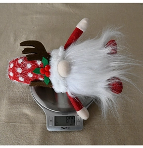 Detail showing Christmas gnome weight on a scale with red polka dot hat and reindeer antlers