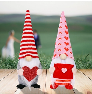 Detail of Valentine Gnomes featuring a red glitter heart and envelope on wood