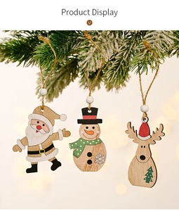 Detail of wooden Christmas ornaments with Santa, Snowman and Reindeer on pine branches