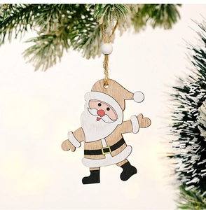 Detail of wooden Santa Claus ornament hanging on snowy pine branch with bokeh background