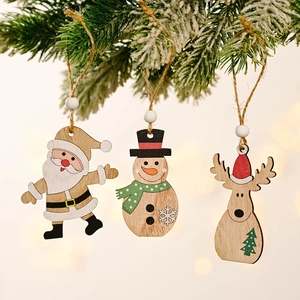 Wooden Christmas tree ornaments with Santa and Reindeer hanging on festive pine branches