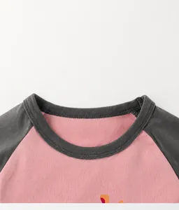 Detail of crew neck ribbing and raglan stitching on girls' cotton long sleeve t-shirt