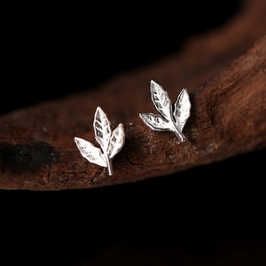 Boucles d'oreilles feuilles en argent avec texture martelée sur support en bois