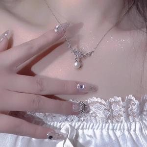 Elegante silberne Blumen-Halskette mit weißer Perle und Kristallen am Modell